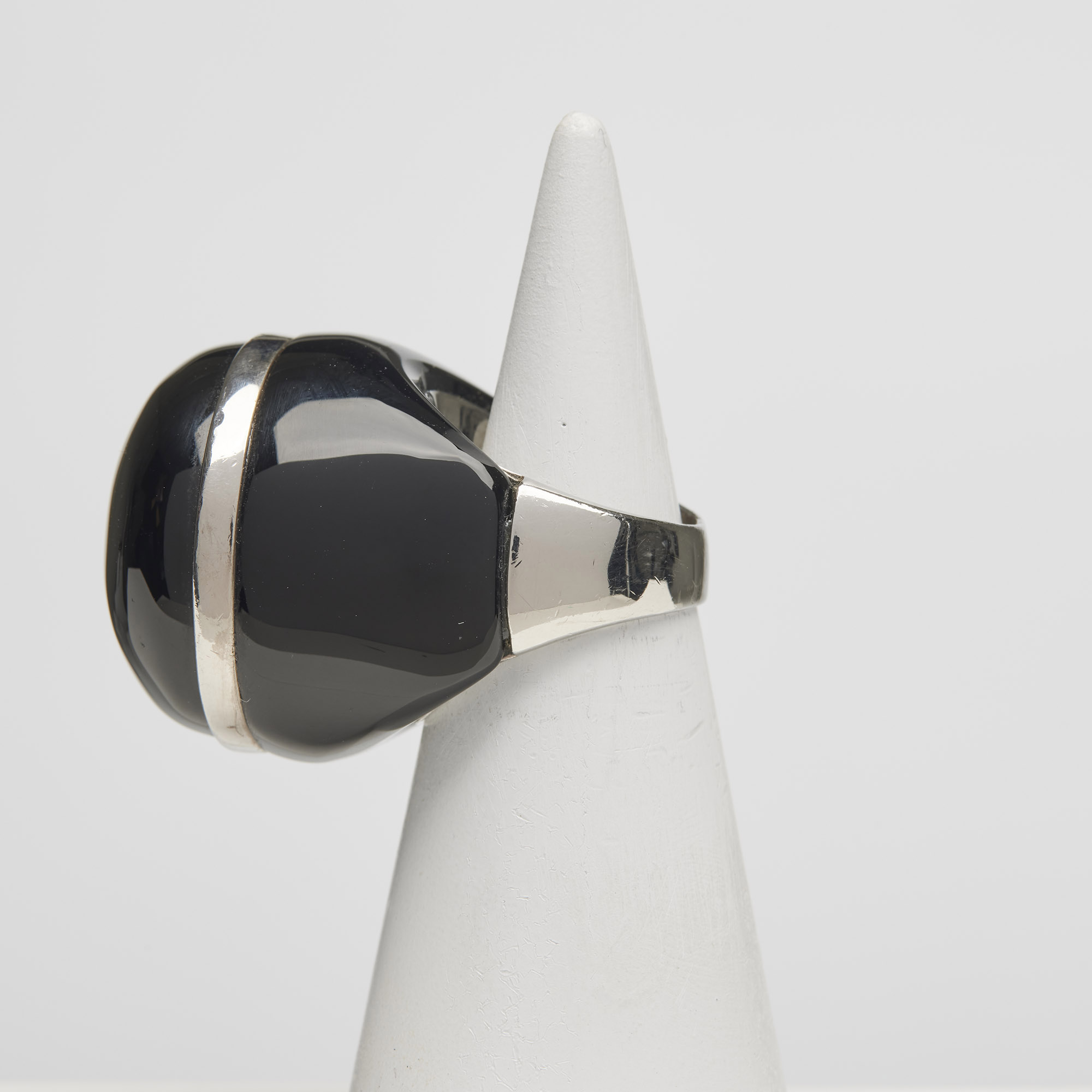 Ring in gerhodineerd 925‰ zilver, met schacht en gefacetteerde cabochon in zwarte agaat. Ring in gerhodineerd 925‰ zilver, met schacht en gefacetteerde cabochon in zwarte agaat.